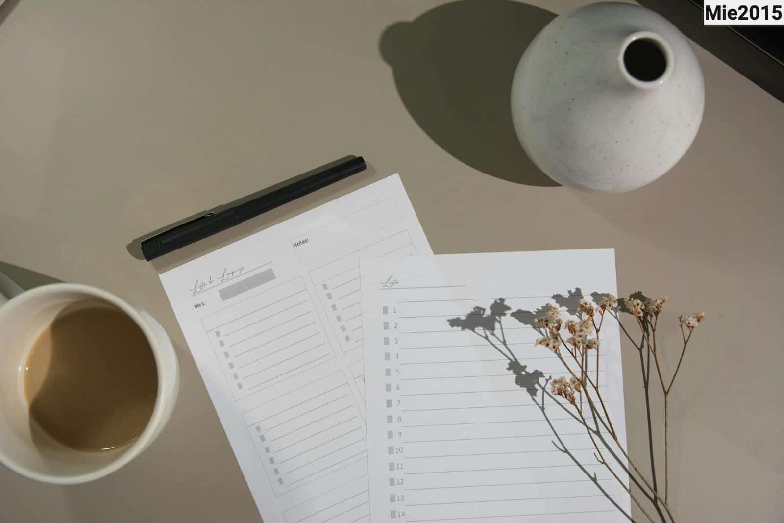 white printer paper beside white ceramic mug